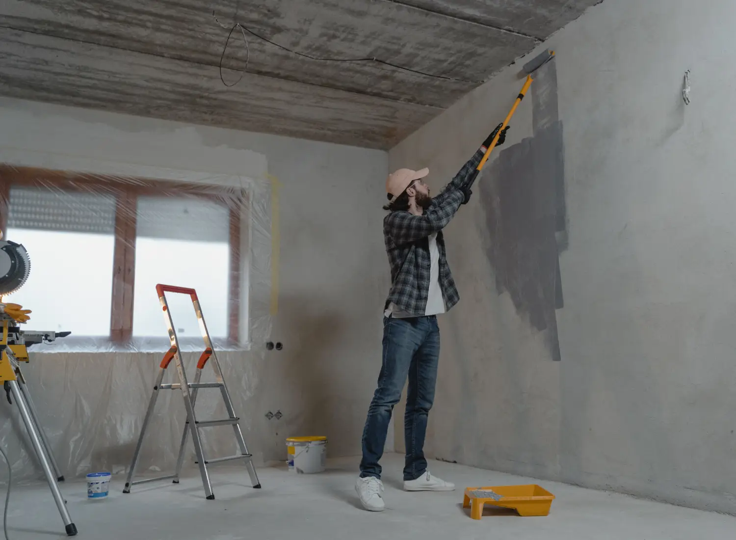 a painter applying primer paint